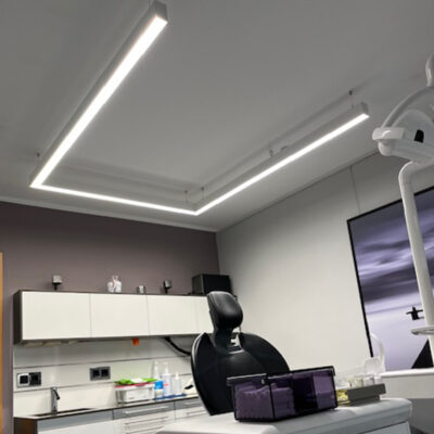 De U-vormige PHU White lamp van DentLed met volledig spectrum is geïnstalleerd in een moderne behandelkamer van een tandheelkundige kliniek in Melle voor precisiewerk in de tandheelkunde.