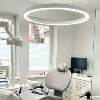 Dentled PVR120 Ring geïnstalleerd in de behandelkamer van de tandartspraktijk Herrmann & Langl, die professionele full-spectrum tandheelkundige verlichting biedt.