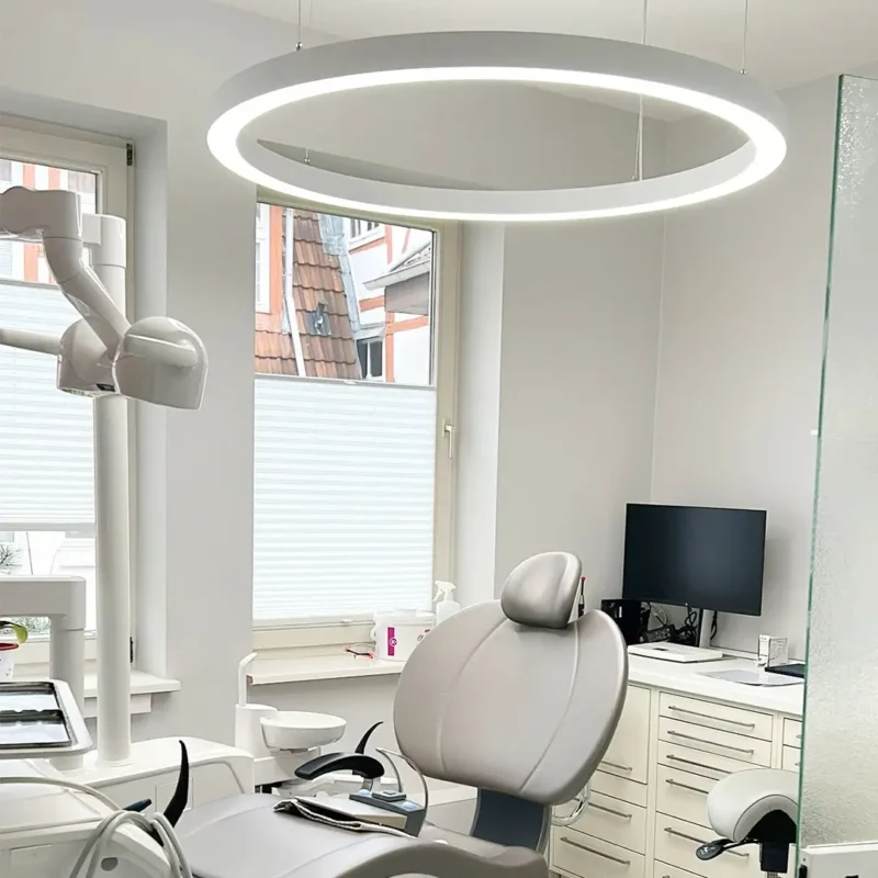 Dentled PVR120 Ring geïnstalleerd in de behandelkamer van de tandartspraktijk Herrmann & Langl, die professionele full-spectrum tandheelkundige verlichting biedt.