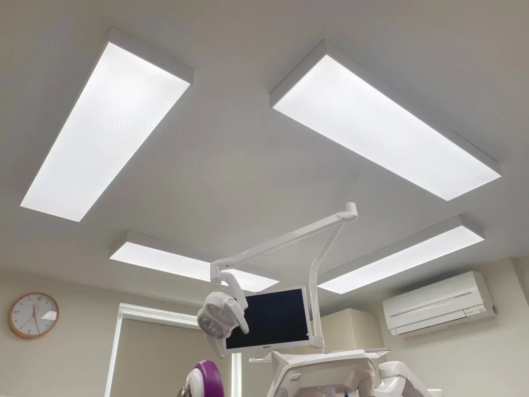 Vier DentLED DL120-ledplafondpanelen met een volledig spectrum in opbouwframes rond de tandartsstoel bij Priory Dental Care.